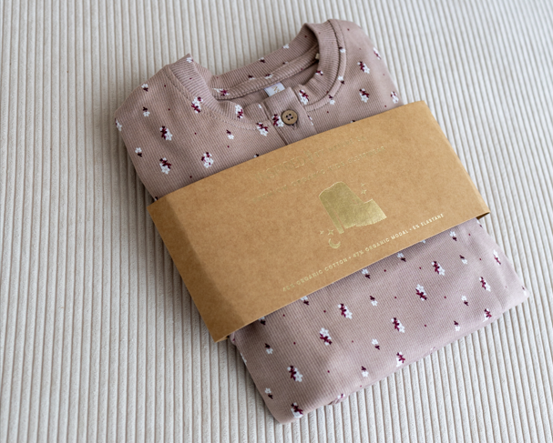 Inspired by Nature SA kids' organic cotton pyjamas in a soft mauve shade with a delicate floral print, folded with a kraft paper wrap, eco-friendly, toxin-free sleepwear crafted for comfort and sustainability.