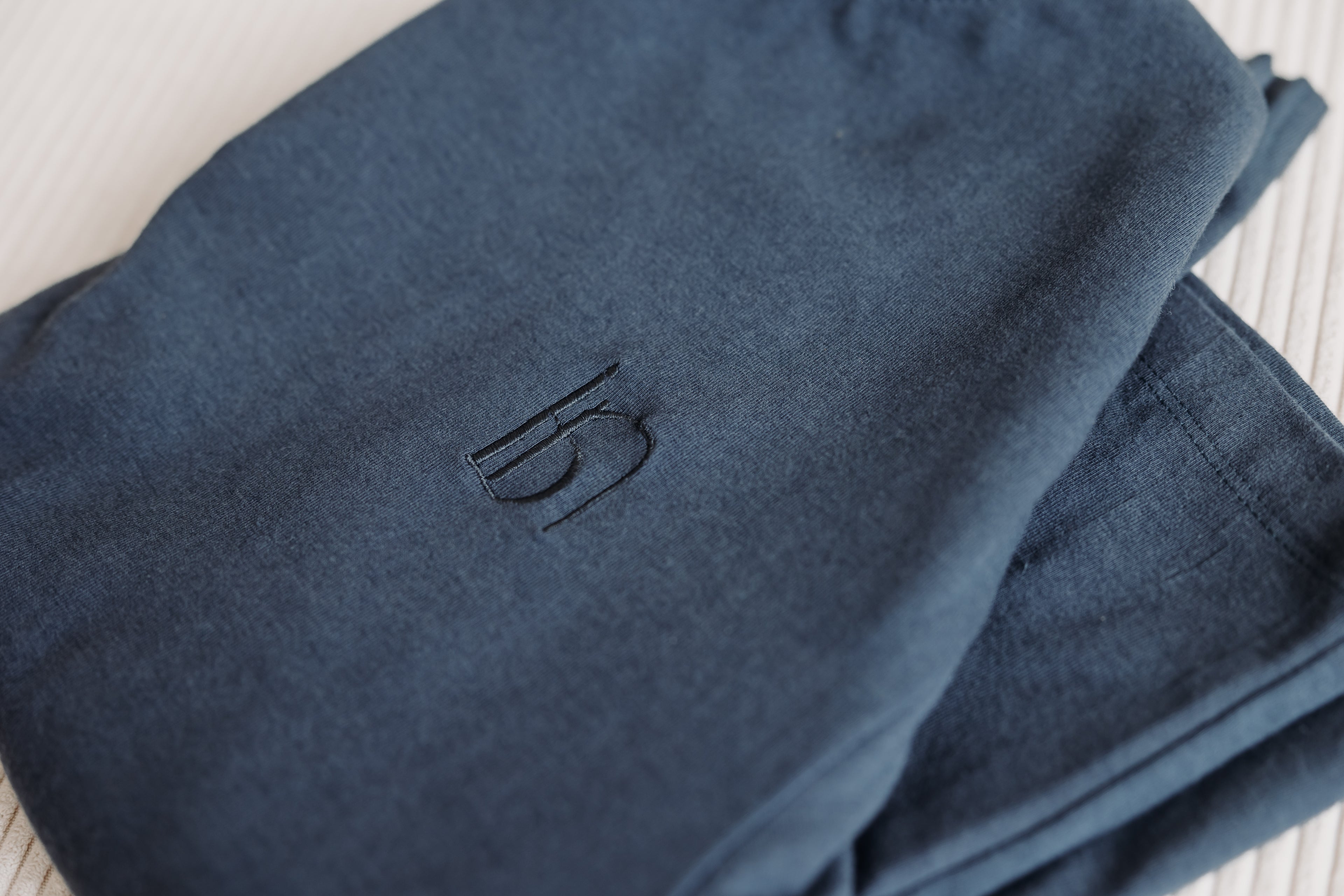 Close-up of Inspired by Nature SA navy pyjama pants made with organic cotton, featuring the embroidered brand logo. Sustainable kids' sleepwear with a soft, breathable finish.







